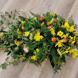 Bright woodland flower and wild foliage single ended funeral coffin spray 
