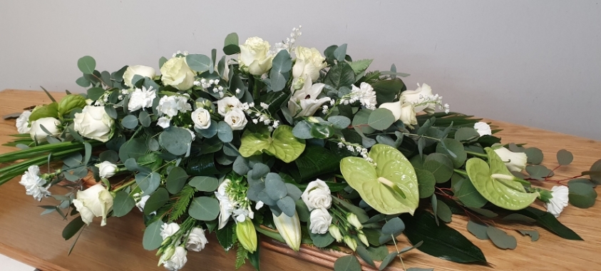 The Serenity Embrace - an ethereal array of white roses, delicate lily of the valley, and refined white carnations, symbolising purity and peace.