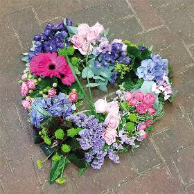 textured pink and purple flower and foliage open heart funeral tribute 