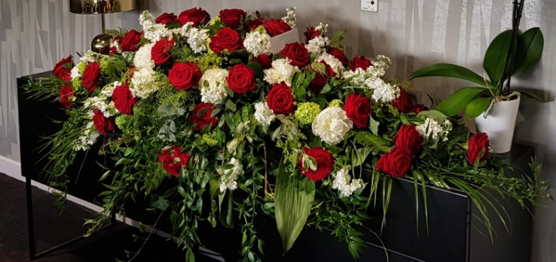 A timeless coffin spray with red roses, white hydrangea, white stocks finished with luxury flowing foliage