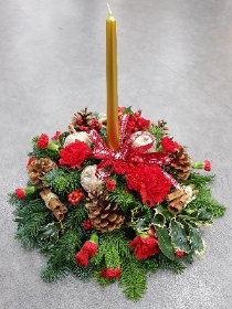 red and gold christmas flower and foliage table centre piece with candle 