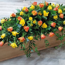 yellow and orange rose flower and foliage double ended funeral coffin spray with ivy and soft ruscus trails