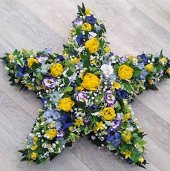 Yellow and purple flower and foliage star shaped funeral tribute 